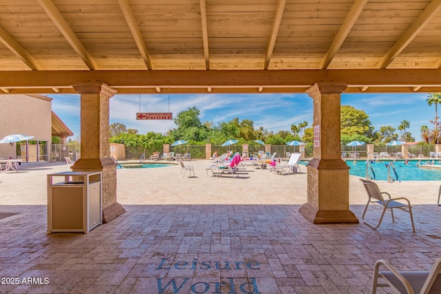 view of patio with fence and a community pool