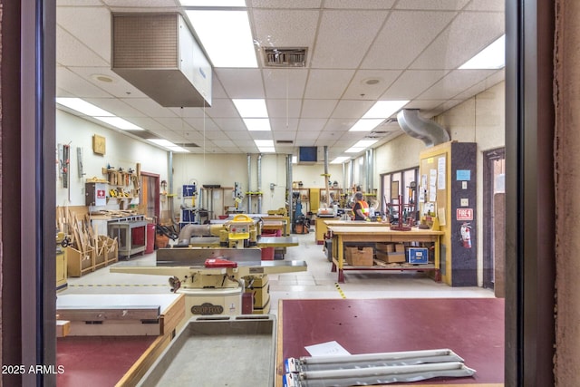 miscellaneous room featuring a drop ceiling, visible vents, and a workshop area