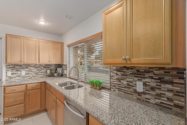 kitchen featuring light tile patterned floors, light stone countertops, a sink, stainless steel dishwasher, and backsplash