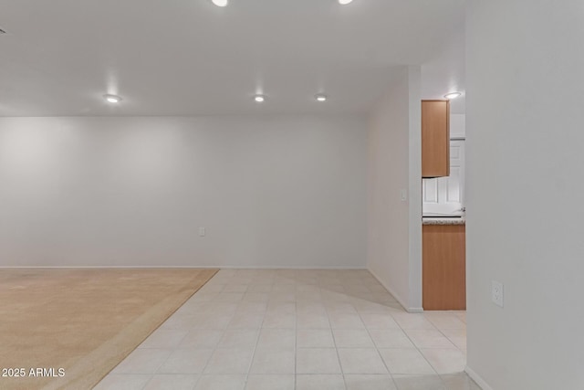 spare room with recessed lighting, light colored carpet, and baseboards