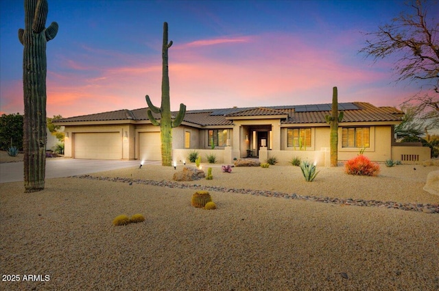 view of front of property featuring solar panels and a garage