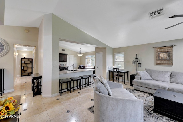 living area with light tile patterned floors, baseboards, visible vents, and vaulted ceiling