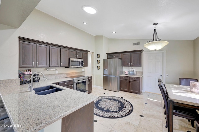 kitchen with stainless steel appliances, a sink, a peninsula, and light stone countertops