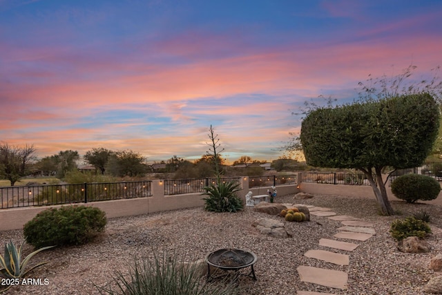 yard at dusk featuring an outdoor fire pit