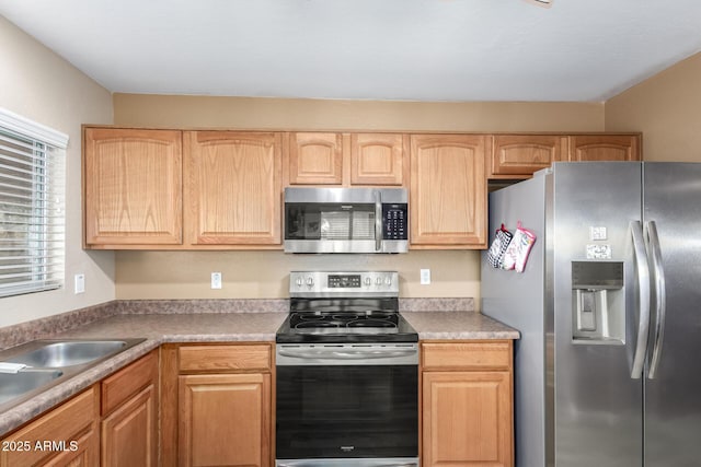 kitchen featuring stainless steel appliances and light brown cabinets