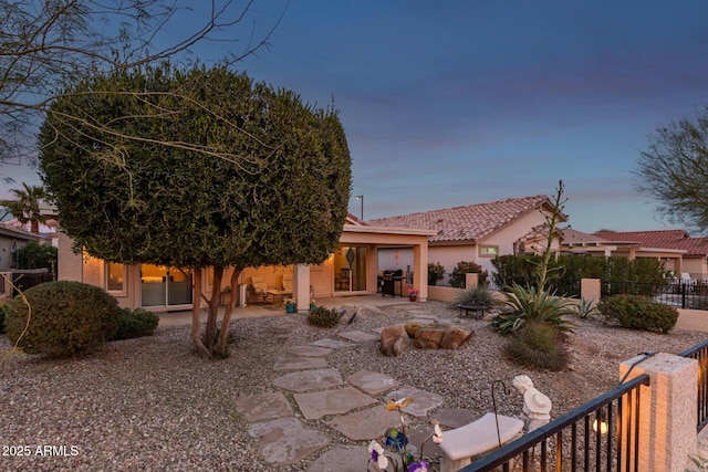 back house at dusk with a patio