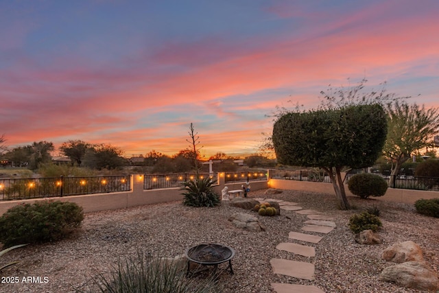 yard at dusk featuring a fire pit