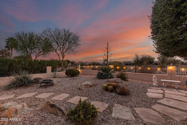 yard at dusk with a patio area and a fire pit