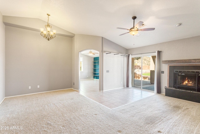 unfurnished living room with ceiling fan with notable chandelier, lofted ceiling, and light colored carpet