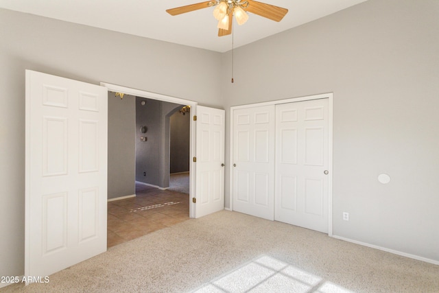 unfurnished bedroom with carpet, ceiling fan, and a closet