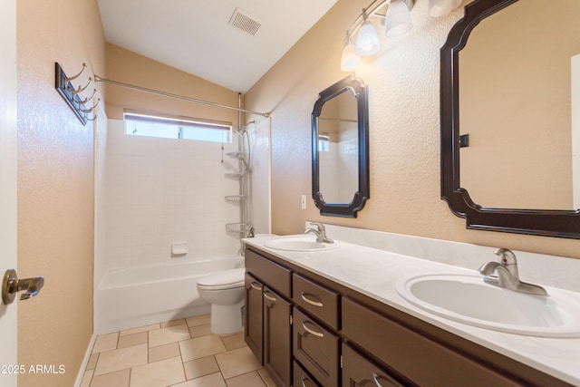 full bathroom featuring tile patterned flooring, tiled shower / bath combo, vanity, vaulted ceiling, and toilet