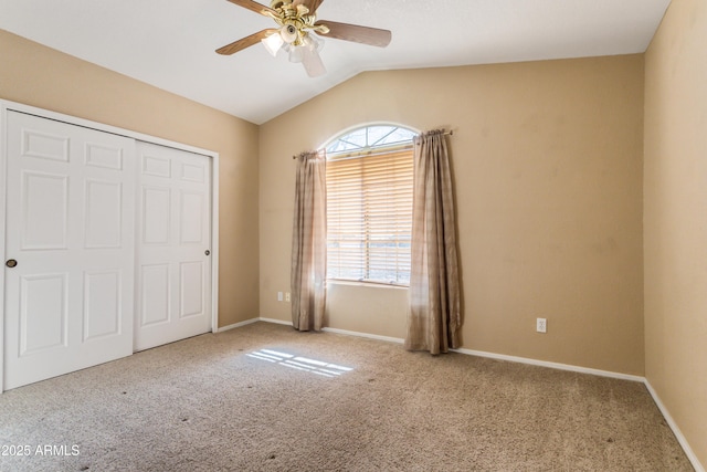 unfurnished bedroom featuring ceiling fan, carpet flooring, vaulted ceiling, and a closet