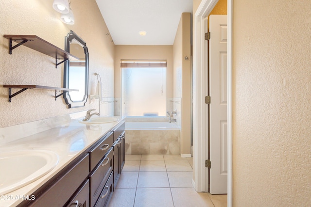 bathroom with tile patterned flooring, vanity, and a relaxing tiled tub