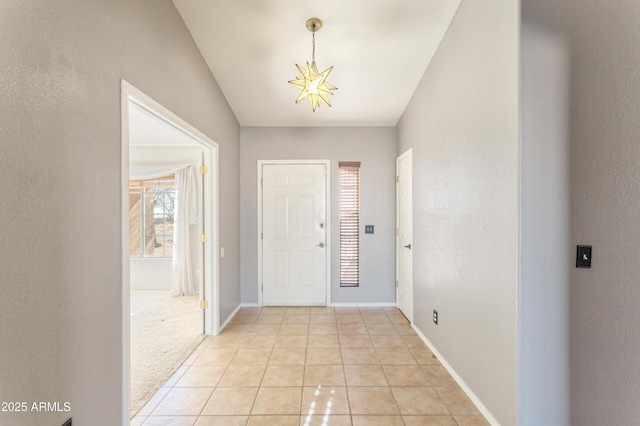 tiled foyer with a chandelier