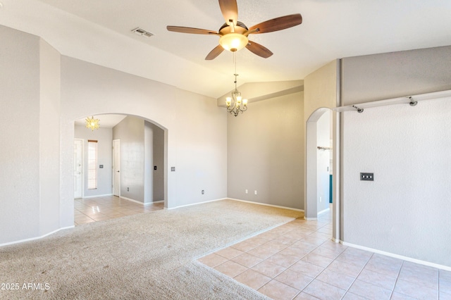 spare room featuring lofted ceiling, ceiling fan with notable chandelier, and light carpet