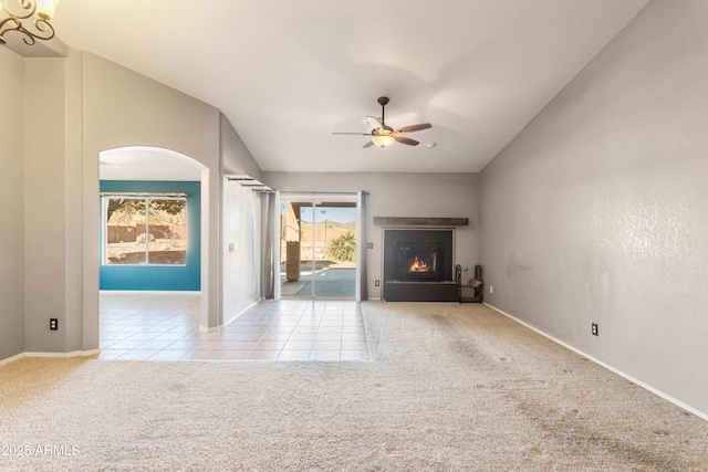 unfurnished living room with ceiling fan, vaulted ceiling, and light carpet