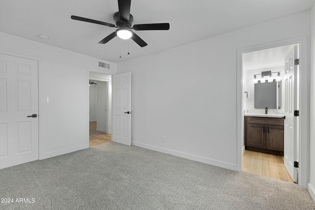 unfurnished bedroom with light carpet, ensuite bath, and ceiling fan