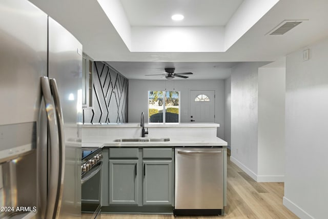 kitchen with sink, light hardwood / wood-style flooring, ceiling fan, gray cabinets, and stainless steel appliances