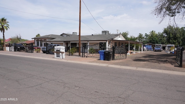 view of front of house featuring a detached carport, a gate, and fence