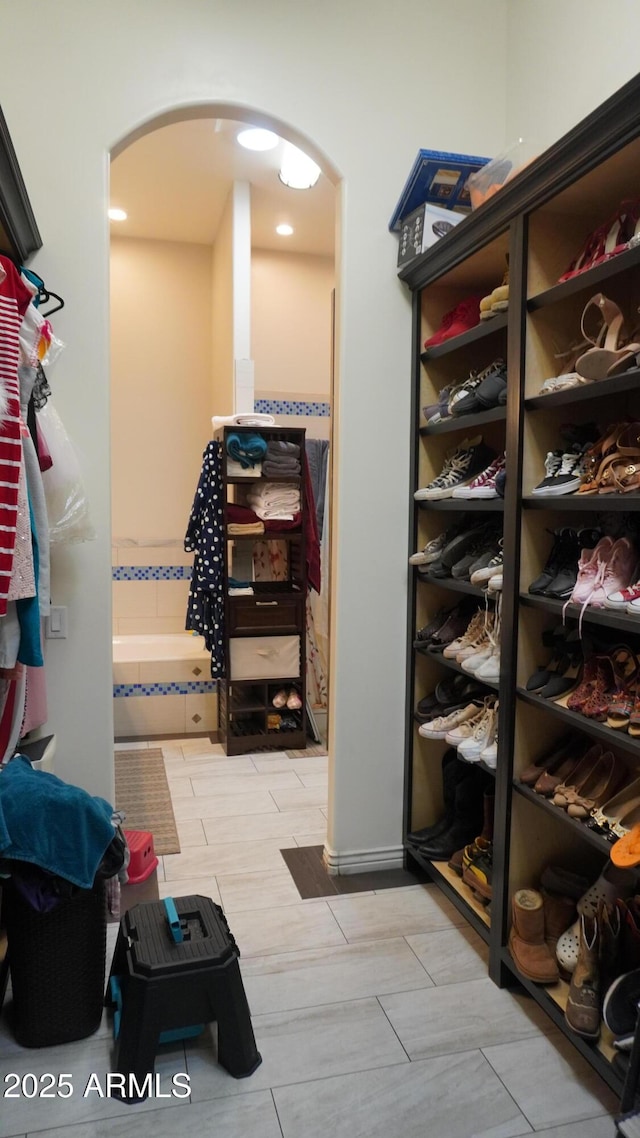 walk in closet featuring arched walkways