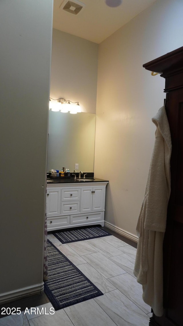 bathroom featuring baseboards, visible vents, and vanity