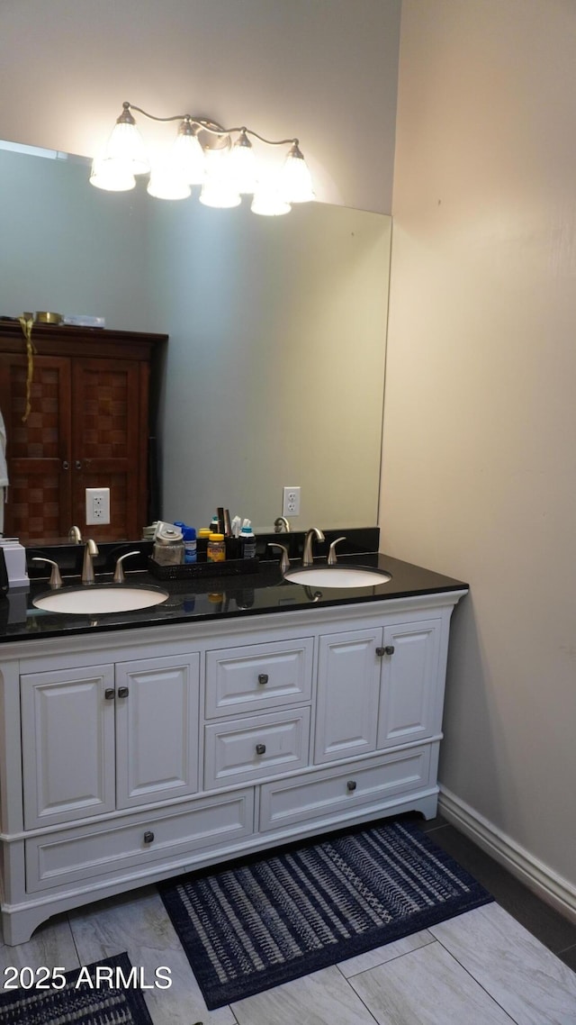 bathroom featuring double vanity, a sink, and baseboards