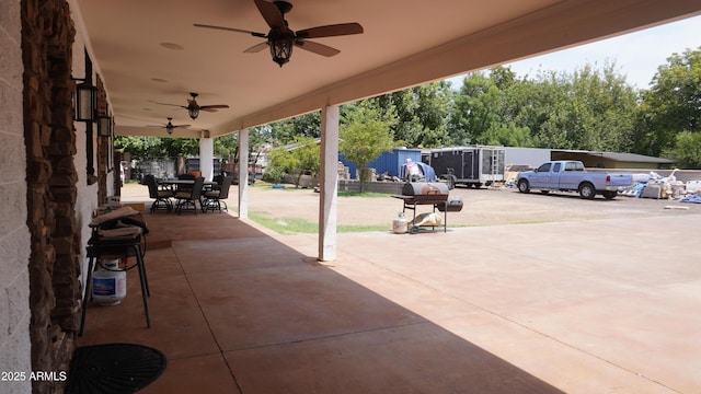 view of patio featuring outdoor dining area, fence, and a ceiling fan