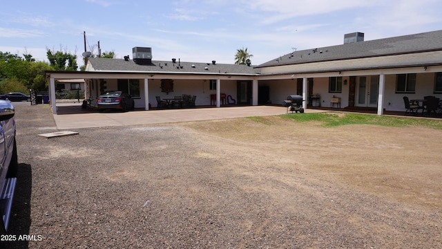 exterior space with cooling unit, a patio, french doors, driveway, and a carport