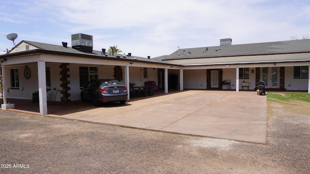 view of front facade featuring an attached carport, driveway, and central air condition unit