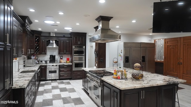 kitchen with recessed lighting, island range hood, a sink, appliances with stainless steel finishes, and wall chimney exhaust hood