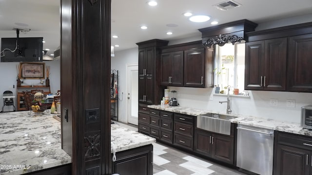 kitchen with a sink, visible vents, stainless steel dishwasher, and light stone counters