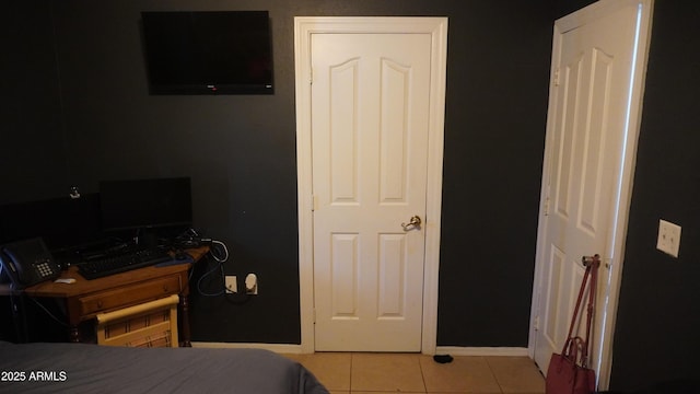 bedroom with baseboards and tile patterned flooring