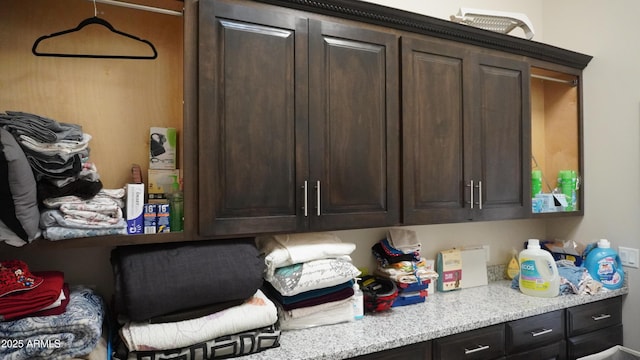 kitchen with light stone countertops and dark brown cabinets