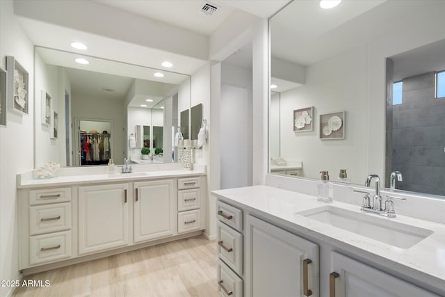 bathroom featuring two vanities, visible vents, and a sink