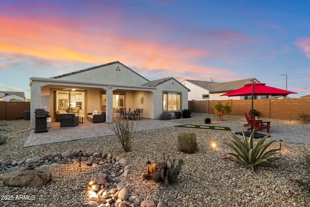 back of property with stucco siding, a patio area, a fenced backyard, and an outdoor hangout area