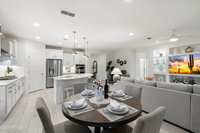 dining space featuring a ceiling fan, recessed lighting, light wood-style floors, and visible vents