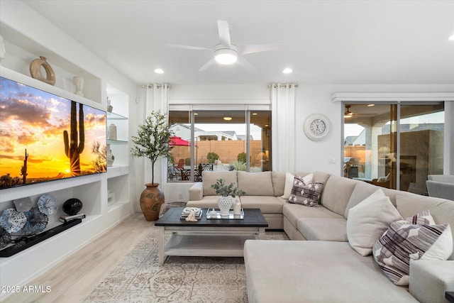 living room with a ceiling fan, recessed lighting, and wood finished floors