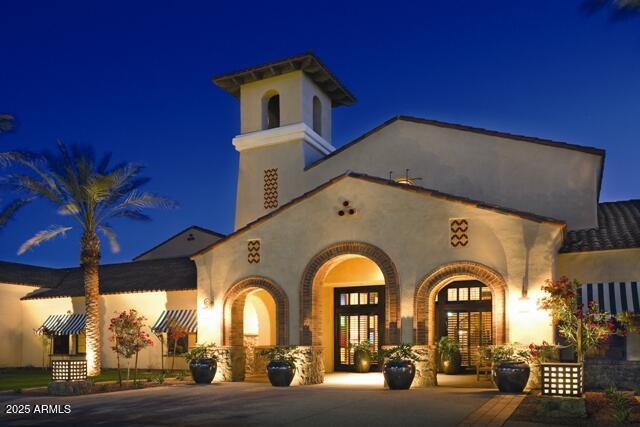 back of house at night featuring stucco siding