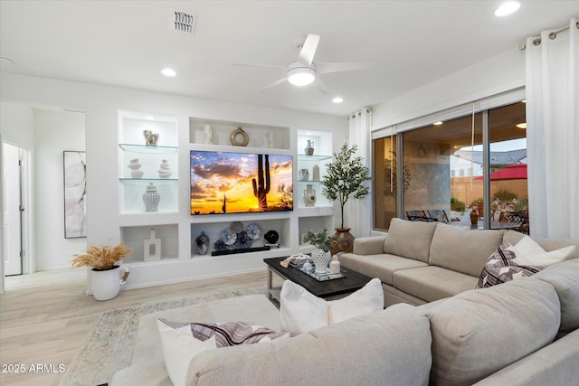 living room with built in features, wood finished floors, visible vents, recessed lighting, and ceiling fan