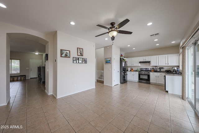 11563 W Jefferson St, Avondale, AZ 85323 - kitchen with gas stove, freestanding refrigerator, arched walkways, under cabinet range hood, and a ceiling fan