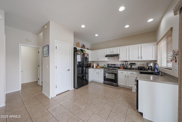 11563 W Jefferson St, Avondale, AZ 85323 - kitchen featuring stainless steel range with gas stovetop, freestanding refrigerator, a sink, under cabinet range hood, and white cabinetry