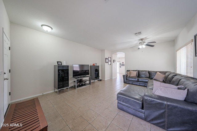 11563 W Jefferson St, Avondale, AZ 85323 - living room featuring arched walkways, light tile patterned floors, a ceiling fan, and baseboards