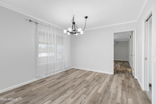 unfurnished dining area with ornamental molding, hardwood / wood-style flooring, and an inviting chandelier