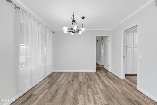 unfurnished dining area with an inviting chandelier, crown molding, and light hardwood / wood-style flooring