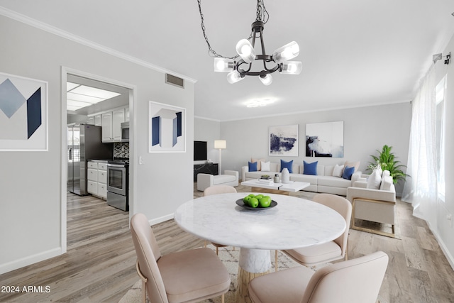 dining room with ornamental molding, a notable chandelier, and light hardwood / wood-style floors