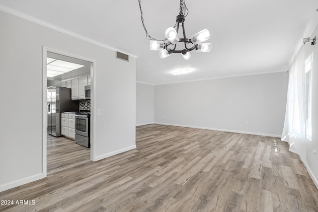 unfurnished dining area with ornamental molding, light wood-type flooring, a healthy amount of sunlight, and a chandelier