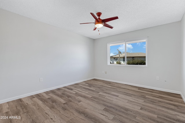 empty room featuring ceiling fan, hardwood / wood-style flooring, and a textured ceiling