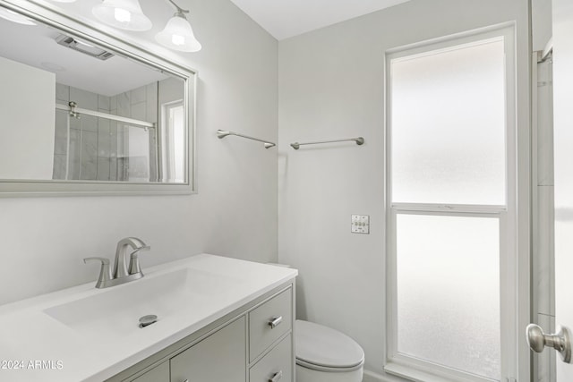 bathroom featuring walk in shower, vanity, and toilet