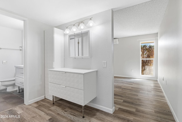 bathroom featuring hardwood / wood-style floors, vanity, toilet, and a textured ceiling