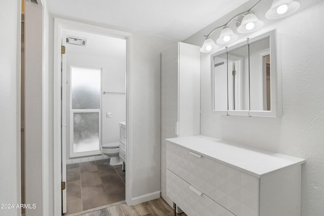 bathroom with hardwood / wood-style floors, vanity, and toilet